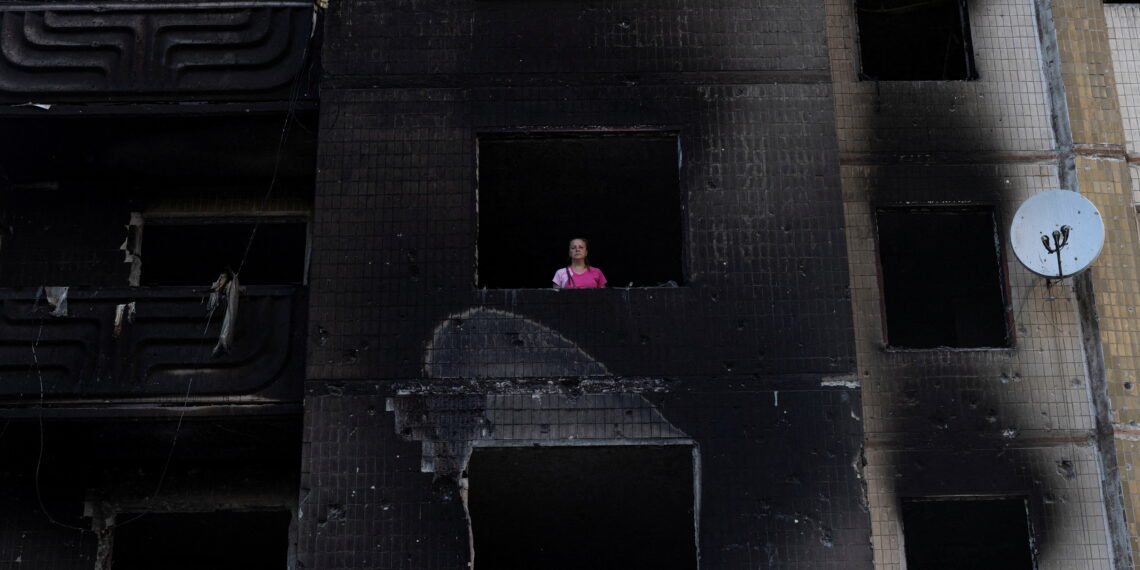 Resident Nataliia Prykhodko looks out from her burnt-out apartment in Irpin after coming back to Ukraine which she and her 17-year-old daughter left as refugees in February, outside Kyiv, as Russia's attacks on Ukraine continues, June 9, 2022. REUTERS/Marko Djurica