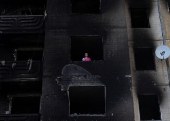 Resident Nataliia Prykhodko looks out from her burnt-out apartment in Irpin after coming back to Ukraine which she and her 17-year-old daughter left as refugees in February, outside Kyiv, as Russia's attacks on Ukraine continues, June 9, 2022. REUTERS/Marko Djurica